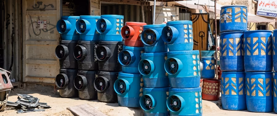 Rows of blue and black Helmandi coolers stacked outside a shop in Afghanistan