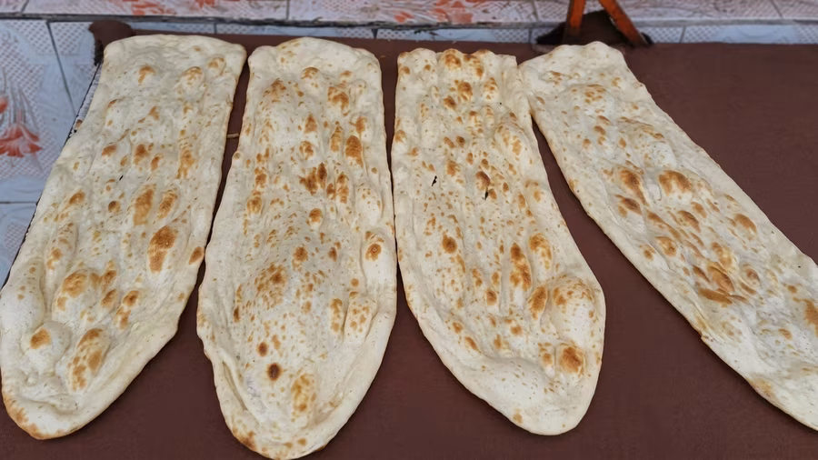 A row of long, tapered flatbreads cooling side by side