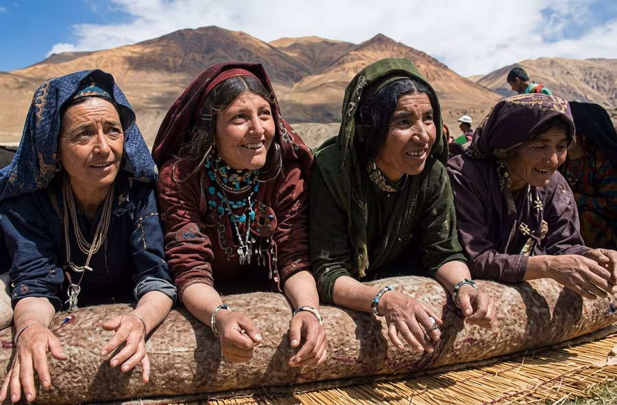 Four women pressing a rolled namad by hand outdoors