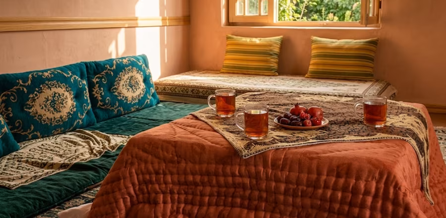 A sandali in an Afghan home — a low table with blankets draped over it